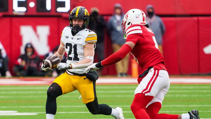 Nov 28, 2025; Lincoln, Nebraska, USA; Iowa Hawkeyes wide receiver Kaden Wetjen (21) runs against Nebraska Cornhuskers defensive back Deshon Singleton (8) during the third quarter at Memorial Stadium. Mandatory Credit: Dylan Widger-Imagn Images