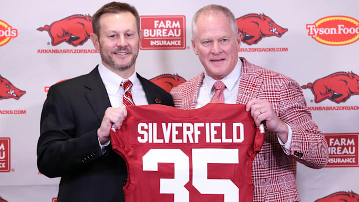 Arkansas Razorbacks coach Ryan Silverfield during his introductory press conference and athletics director Hunter Yurachek pose with a jersey with the number 35 signifying the 35th Arkansas head coach at Frank Broyles Center.