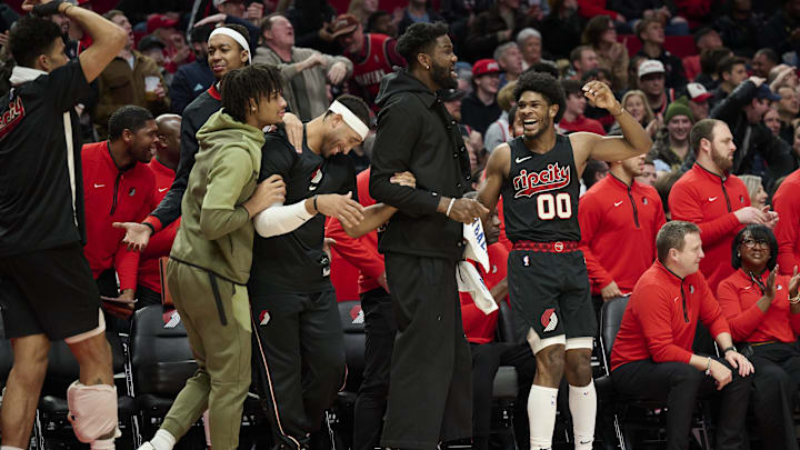 Dec 29, 2023; Portland, Oregon, USA; Portland Trail Blazers guard Scoot Henderson (00), right, reacts with teammates, from left, guard Shaedon Sharpe (17), forward Ish Wainright (23), and center Deandre Ayton (2) after a play during the second half against the San Antonio Spurs at Moda Center. Mandatory Credit: Troy Wayrynen-Imagn Images