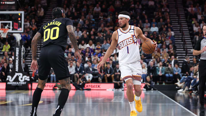 Nov 12, 2024; Salt Lake City, Utah, USA; Phoenix Suns guard Devin Booker (1) brings the ball up the court against Utah Jazz guard Jordan Clarkson (00) during the second quarter at Delta Center. Mandatory Credit: Rob Gray-Imagn Images