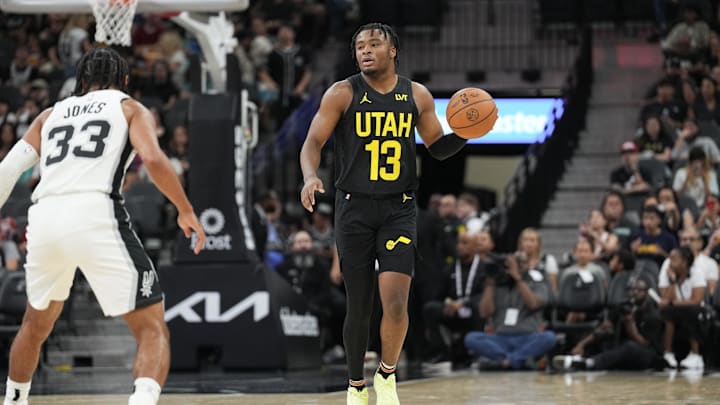Oct 12, 2024; San Antonio, Texas, USA;  Utah Jazz guard Isaiah Collier (13) dribbles the ball in front of San Antonio Spurs guard Tre Jones (33) in the first half at Frost Bank Center. Mandatory Credit: Daniel Dunn-Imagn Images