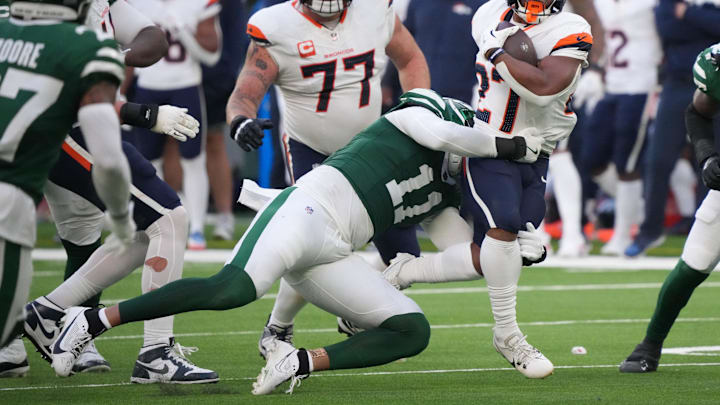 Oct 12, 2025; Tottenham, United Kingdom; Denver Broncos running back J.K. Dobbins (27) runs the ball against New York Jets linebacker Jermaine Johnson II (11) during an NFL International Series game at Tottenham Hotspur Stadium. Mandatory Credit: Kirby Lee-Imagn Images