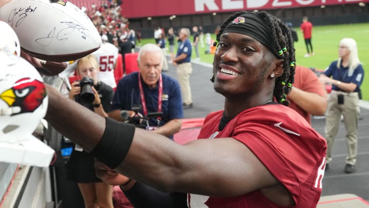 Arizona Cardinals receiver Marvin Harrison Jr. (18) signs autographs for fans during training camp at State Farm Stadium in Glendale on July 28, 2024.`