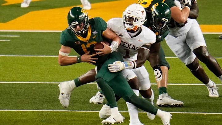 Sep 23, 2023; Waco, Texas, USA;  Baylor Bears quarterback Sawyer Robertson (13) is sacked by Texas Longhorns defensive end Justice Finkley (1) during the second half at McLane Stadium. Mandatory Credit: Chris Jones-Imagn Images