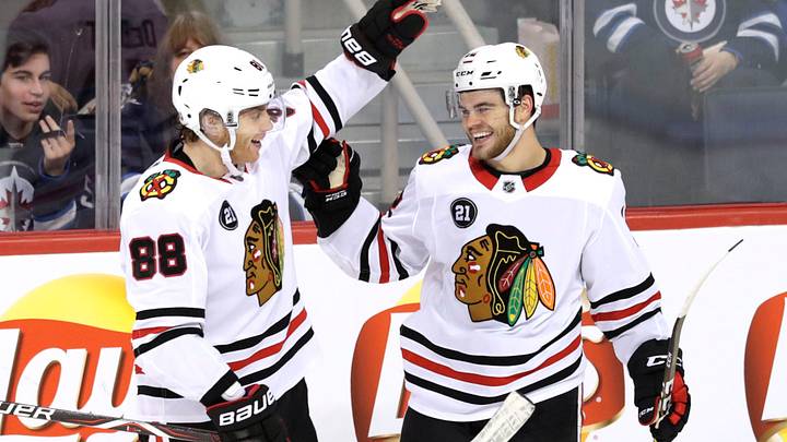 Dec 11, 2018; Winnipeg, Manitoba, CAN; Chicago Blackhawks left wing Alex DeBrincat (12) celebrates his third period goal against Winnipeg Jets with Blackhawks right wing Patrick Kane (88) at Bell MTS Place. Mandatory Credit: James Carey Lauder-USA TODAY Sports