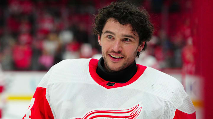 Detroit Red Wings goaltender Alex Lyon (34) smiles at teammates as he stands near the bench during warm-ups.