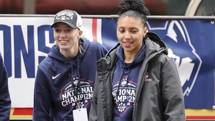 UConn student-athlete Paige Bueckers and UConn student-athlete Azzi Fudd walk onto the stage during the Final Four Champions victory parade and rally outside of the XL Center in Hartford, CT.