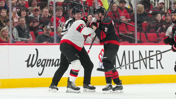 Feb 3, 2026; Raleigh, North Carolina, USA;  Carolina Hurricanes right wing Andrei Svechnikov (37) and Ottawa Senators center Shane Pinto (12) battle during the first period at Lenovo Center. Mandatory Credit: James Guillory-Imagn Images