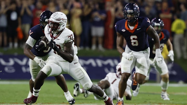 Sep 26, 2025; Charlottesville, Virginia, USA; Florida State Seminoles running back Ousmane Kromah (32) carries the ball past Virginia Cavaliers defensive end Cazeem Moore (6) at Scott Stadium. Mandatory Credit: Geoff Burke-Imagn Images Sep 26, 2025; Charlottesville, Virginia, USA; Florida State Seminoles running back Ousmane Kromah (32) carries the ball past Virginia Cavaliers defensive end Cazeem Moore (6) at Scott Stadium. Mandatory Credit: Geoff Burke-Imagn Images