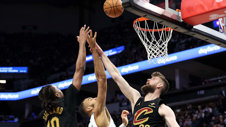 Jan 18, 2025; Minneapolis, Minnesota, USA; Minnesota Timberwolves center Rudy Gobert (27) shoots as Cleveland Cavaliers guard Darius Garland (10) and forward Dean Wade (32) defend during the second quarter at Target Center. Mandatory Credit: Matt Krohn-Imagn Images