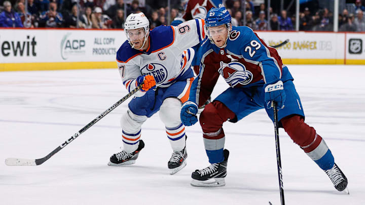 Feb 19, 2023; Denver, Colorado, USA; Colorado Avalanche center Nathan MacKinnon (29) controls the puck ahead of Edmonton Oilers center Connor McDavid (97) in overtime at Ball Arena. Mandatory Credit: Isaiah J. Downing-Imagn Images