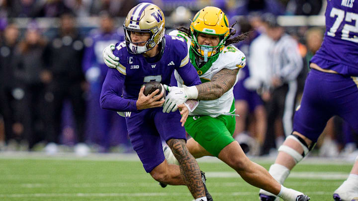 Oregon outside linebacker Matayo Uiagalelei, right, pressures Washington quarterback Demond Williams Jr. as the Oregon Ducks take on the Washington Huskies on Nov. 29, 2025, at Husky Stadium in Seattle, Washington.
