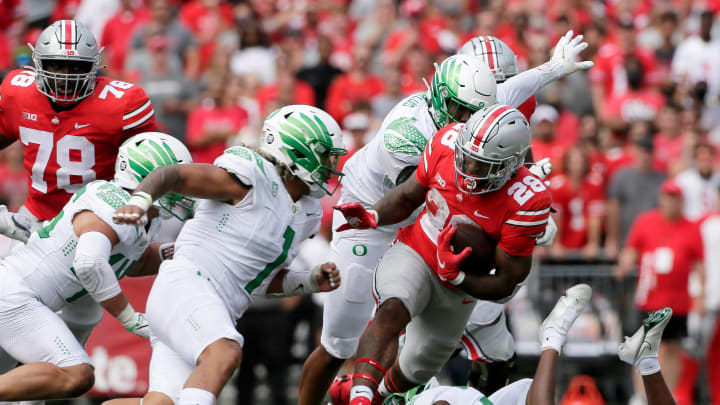 Ohio State Buckeyes running back Miyan Williams (28) is pursued by Oregon Ducks linebacker Noah Sewell (1) during Saturday's NCAA Division I football game at Ohio Stadium in Columbus on September 11, 2021.