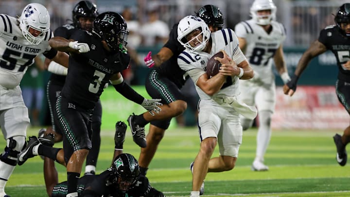 Oct 11, 2025; Honolulu, Hawaii, USA;  Utah State Aggies quarterback Bryson Barnes (16) runs away from the Hawaii Rainbow Warriors defense during the second half at Clarence T.C. Ching Athletics Complex. Mandatory Credit: Marco Garcia-Imagn Images