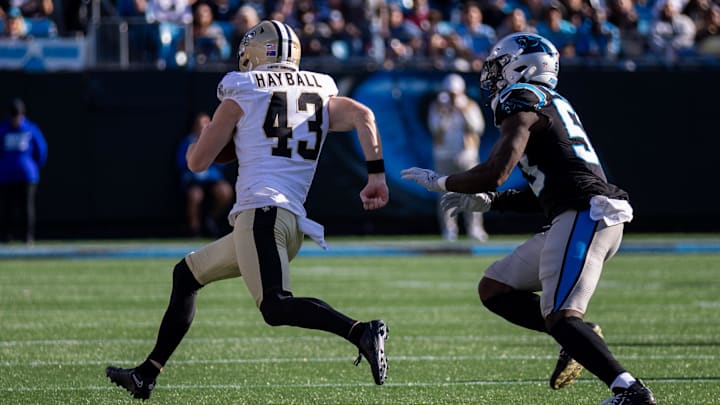 Nov 3, 2024; Charlotte, North Carolina, USA; New Orleans Saints punter Matthew Hayball (43) runs by Carolina Panthers linebacker Claudin Cherelus (53) for a first down on a fake punt during the third quarter at Bank of America Stadium.