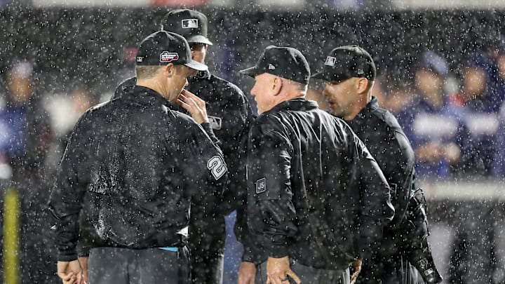Aug 2, 2025; Bristol, Tennessee, USA; The umpires speak as rain falls during the first inning of the Speedway Classic game between the Cincinnati Reds and the Atlanta Braves at Bristol Motor Speedway. Mandatory Credit: Randy Sartin-Imagn Images