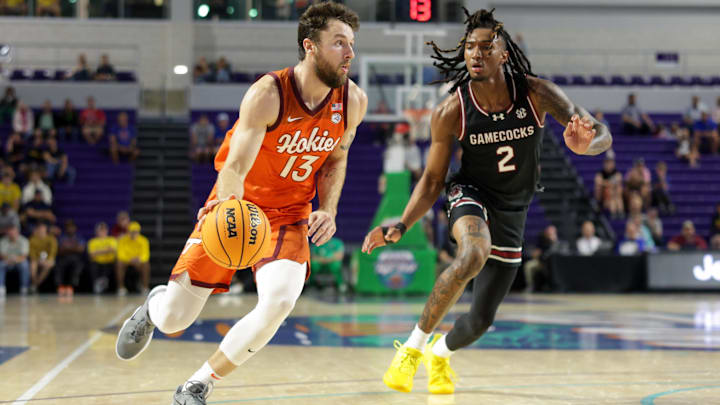 Nov 27, 2024; Fort Myers, Florida, USA; Virginia Tech Hokies forward Ben Burnham (13) drives to the hoop past South Carolina Gamecocks guard Zachary Davis (2) in the first half at Suncoast Credit Union Arena. Mandatory Credit: Nathan Ray Seebeck-Imagn Images