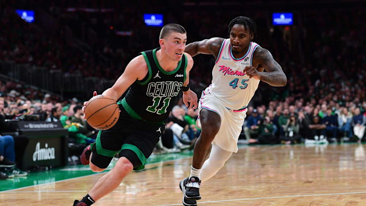 Apr 2, 2025; Boston, Massachusetts, USA; Boston Celtics guard Payton Pritchard (11) controls the ball while Miami Heat guard Davion Mitchell (45) defends during the second half at TD Garden. Mandatory Credit: Bob DeChiara-Imagn Images