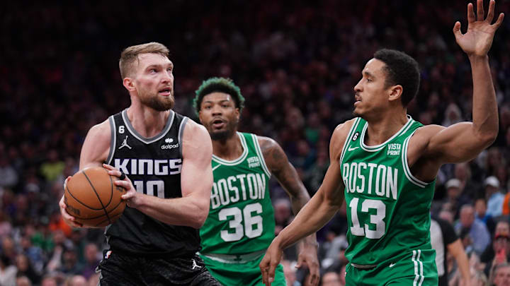 Mar 21, 2023; Sacramento, California, USA; Sacramento Kings forward Domantas Sabonis (10) holds onto the ball next to Boston Celtics guard Malcolm Brogdon (13) in the fourth quarter at the Golden 1 Center. Mandatory Credit: Cary Edmondson-Imagn Images