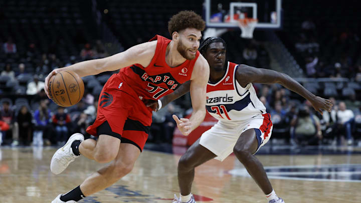 Oct 11, 2024; Washington, District of Columbia, USA; Toronto Raptors forward Jamison Battle (77) drives to the basket as Washington Wizards guard Kira Lewis Jr. (31) defends in the fourth quarter at Capital One Arena. Mandatory Credit: Geoff Burke-Imagn Images