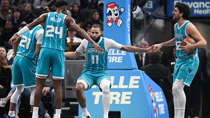 Dec 8, 2024; Indianapolis, Indiana, USA; Charlotte Hornets forward Cody Martin (11) is helped up by Charlotte Hornets guard Isaiah Wong (21) and Charlotte Hornets guard Vasilije Micic (22) after drawing a charge during the second half against the Indiana Pacers at Gainbridge Fieldhouse. Mandatory Credit: Robert Goddin-Imagn Images 