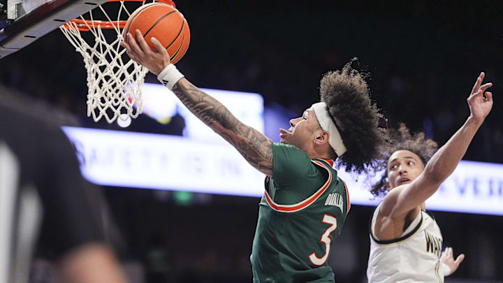 Jan 7, 2026; Winston-Salem, North Carolina, USA; Miami (FL) Hurricanes guard Tre Donaldson (3) goes to the basket against Wake Forest Demon Deacons guard Nate Calmese (1) during the second half at Lawrence Joel Veterans Memorial Coliseum. Mandatory Credit: Jim Dedmon-Imagn Images