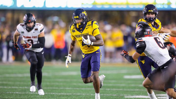 Sep 26, 2026; Morgantown, West Virginia, USA;  West Virginia Mountaineers running back Cam Cook (4) runs the ball during the first quarter against the Oklahoma State Cowboys at Milan Puskar Stadium.  Mandatory Credit: Ben Queen-Imagn Images