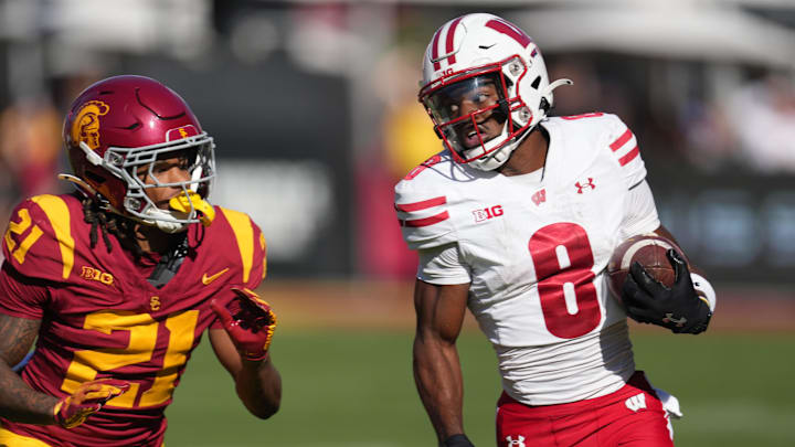 Sep 28, 2024; Los Angeles, California, USA; Wisconsin Badgers wide receiver Vinny Anthony II (8) carries the ball against Southern California Trojans cornerback Greedy Vance Jr. (21) in the second half at United Airlines Field at Los Angeles Memorial Coliseum. Mandatory Credit: Kirby Lee-Imagn Images