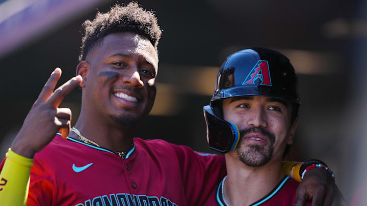 Sep 18, 2024; Denver, Colorado, USA; Arizona Diamondbacks outfielder Corbin Carroll (7) (right) celebrates his solo home run with shortstop Geraldo Perdomo (2) (left) in the first inning against the Colorado Rockies at Coors Field. Mandatory Credit: Ron Chenoy-Imagn Images