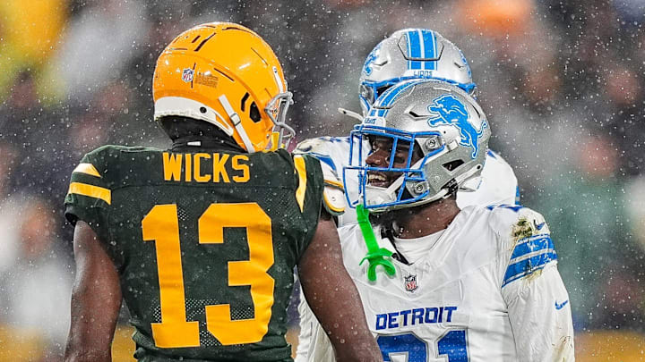Detroit Lions cornerback Amik Robertson (21) talks to Green Bay Packers wide receiver Dontayvion Wicks (13).
