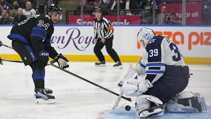 Jan 24, 2024; Toronto, Ontario, CAN; Winnipeg Jets goaltender Laurent Brossoit (39) makes a save on Toronto Maple Leafs forward Auston Matthews (34) during the third period at Scotiabank Arena. Mandatory Credit: John E. Sokolowski-Imagn Images