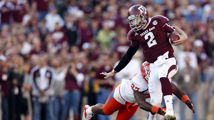 Nov 17, 2012; College Station, TX, USA;  Texas A&M Aggies quarterback Johnny Manziel (2) breaks a tackle by Sam Houston State Bearkats defensive back Mike Littleton (27) during the first half at Kyle Field. Mandatory Credit: Thomas Campbell-Imagn Images