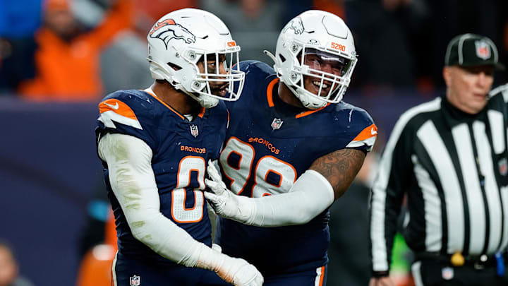 Dec 2, 2024; Denver, Colorado, USA; Denver Broncos linebacker Jonathon Cooper (0) reacts with defensive end John Franklin-Myers (98) after a play in the fourth quarter against the Cleveland Browns at Empower Field at Mile High. Mandatory Credit: Isaiah J. Downing-Imagn Images