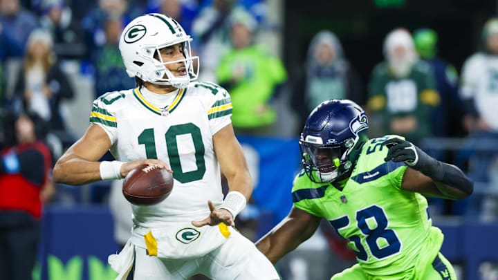 Dec 15, 2024; Seattle, Washington, USA; Green Bay Packers quarterback Jordan Love (10) passes while under pressure from Seattle Seahawks linebacker Derick Hall (58) during the second quarter at Lumen Field. Mandatory Credit: Joe Nicholson-Imagn Images