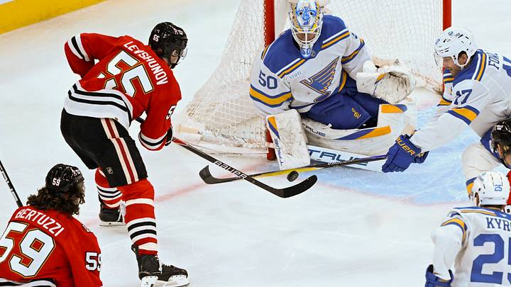 Jan 7, 2026; Chicago, Illinois, USA;  St. Louis Blues goaltender Jordan Binnington (50) defends against Chicago Blackhawks defenseman Artyom Levshunov (55)  during the third period at the United Center. Mandatory Credit: Matt Marton-Imagn Images