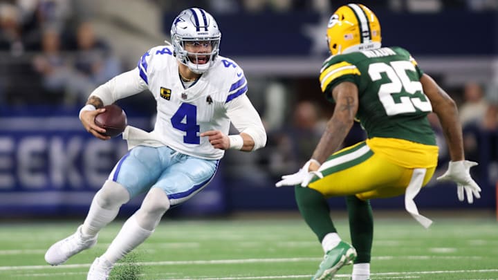 Jan 14, 2024; Arlington, Texas, USA; Dallas Cowboys quarterback Dak Prescott (4) rushes the ball against Green Bay Packers cornerback Keisean Nixon (25) during the second half of the  2024 NFC wild card game at AT&T Stadium.