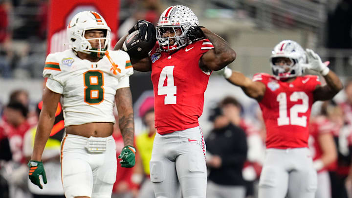 Ohio State Buckeyes wide receiver Jeremiah Smith (4) celebrates a first down beside Miami Hurricanes defensive back Jakobe Thomas (8)