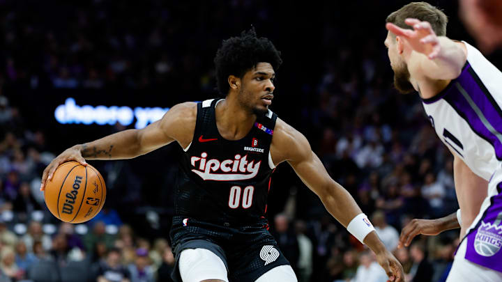 Mar 27, 2025; Sacramento, California, USA; Portland Trail Blazers guard Scoot Henderson (00) dribbles against Sacramento Kings forward Domantas Sabonis (11) during the third quarter at Golden 1 Center. Mandatory Credit: Sergio Estrada-Imagn Images