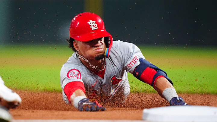Sep 25, 2024; Denver, Colorado, USA; St. Louis Cardinals shortstop Masyn Winn (0) slides for a triple in the third inning against the Colorado Rockies at Coors Field. Mandatory Credit: Ron Chenoy-Imagn Images