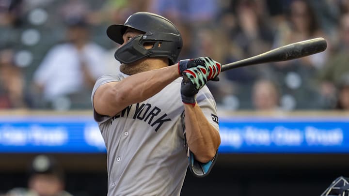 Sep 16, 2025; Minneapolis, Minnesota, USA; New York Yankees designated hitter Giancarlo Stanton (27) hits a RBI sacrifice fly against the Minnesota Twins in the first inning at Target Field. Mandatory Credit: Jesse Johnson-Imagn Images