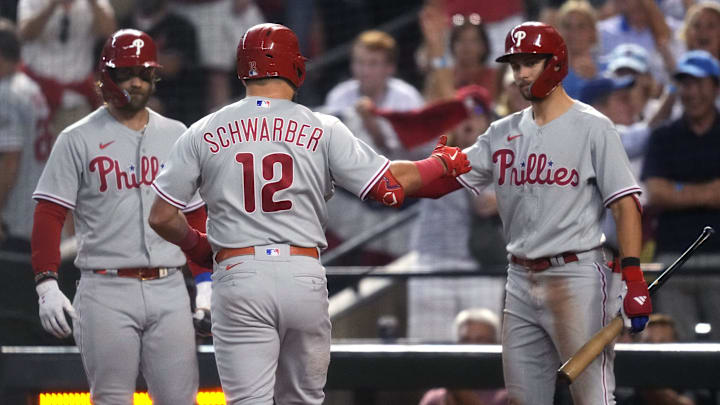 Philadelphia Phillies designated hitter Kyle Schwarber (12) celebrates with shortstop Trea Turner (right) and first baseman Bryce Harper (left) after hitting a home run during the fourth inning against the Arizona Diamondbacks in game four of the NLCS of the 2023 MLB playoffs at Chase Field in Phoenix on Oct. 20, 2023.