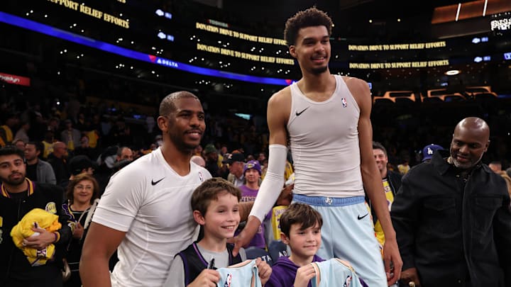 Jan 13, 2025; Los Angeles, California, USA;  San Antonio Spurs guard Chris Paul (3, left) and center Victor Wembanyama (1,right) pose for a photo with Los Angeles Lakers head coach JJ Redick's sons after defeating the Lakers 126-102 at Crypto.com Arena. Mandatory Credit: Kiyoshi Mio-Imagn Images