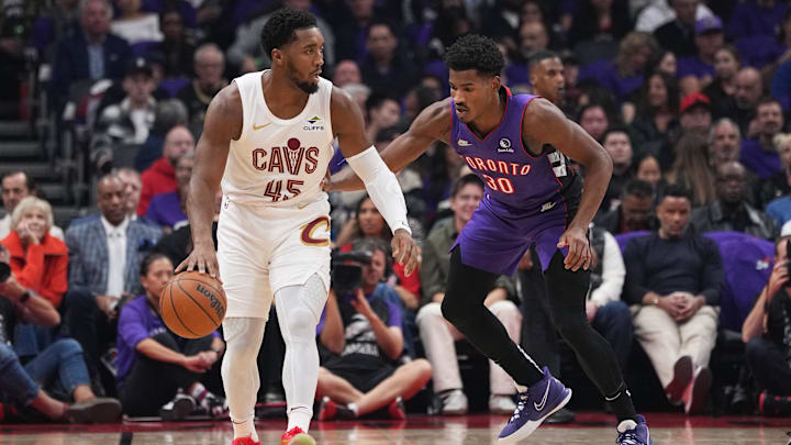 Oct 23, 2024; Toronto, Ontario, CAN; Cleveland Cavaliers guard Donovan Mitchell (45) controls the ball as Toronto Raptors guard Ochai Agbaji (30) defends during the first quarter at Scotiabank Arena. Mandatory Credit: Nick Turchiaro-Imagn Images