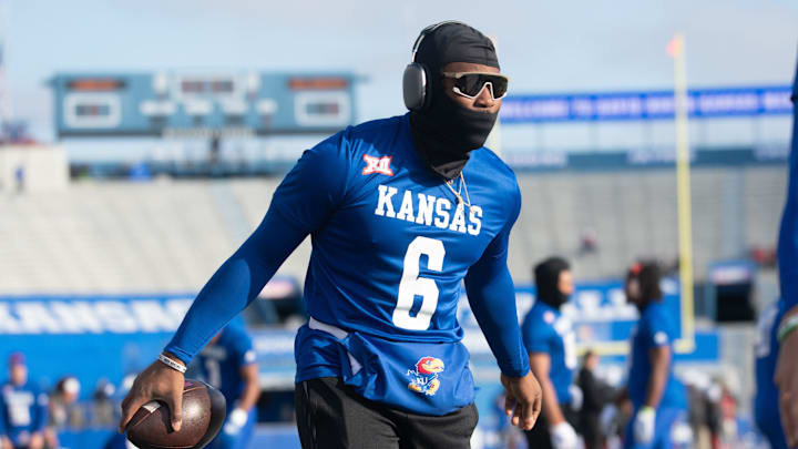 Kansas junior quarterback Jalon Daniels (6) grabs a ball during pregame before Saturday's game against Oklahoma inside David Booth Kansas Memorial Stadium.
