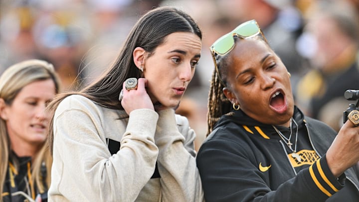 Oct 26, 2024; Iowa City, Iowa, USA; Former Iowa Hawkeye and current Indiana Fever WNBA star Caitlin Clark (left) reacts with friends and family while being honored during the game between the Iowa Hawkeyes and the Northwestern Wildcats at Kinnick Stadium. Mandatory Credit: Jeffrey Becker-Imagn Images
