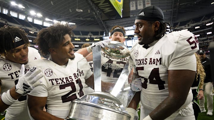 Sep 30, 2023; Arlington, Texas, USA; Texas A&M Aggies linebacker Taurean York (21) and linebacker Danny Lockhart Jr. (54) celebrate with the Southwest Classic trophy after the Aggies victory over the Arkansas Razorbacks at AT&T Stadium. Mandatory Credit: Jerome Miron-Imagn Images