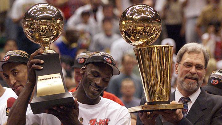 Michael Jordan holds the MVP trophy and coach Phil Jackson holds the championship trophy after the Bulls beat the Jazz to win their sixth title in 1998. Michael Jordan holds the MVP trophy and coach Phil Jackson holds the championship trophy after the Bulls beat the Jazz to win their sixth title in 1998.