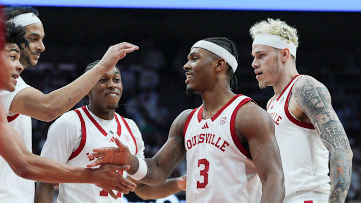 Mikel Brown Jr. (0), left, celebrates with Ryan Conwell (3) as guard Adrian Wooley (14) and forward Kasean Pryor (7) look on in the first half against NC State at the KFC Yum! Center in downtown Louisville February 9, 2026.