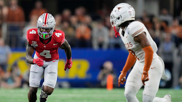 Ohio State Buckeyes wide receiver Jeremiah Smith (4) tries to get open against Texas Longhorns defensive back Jahdae Barron (7) in the fourth quarter of the Cotton Bowl Classic during the College Football Playoff semifinal game at AT&T Stadium in Arlington, Texas on January, 10, 2025.