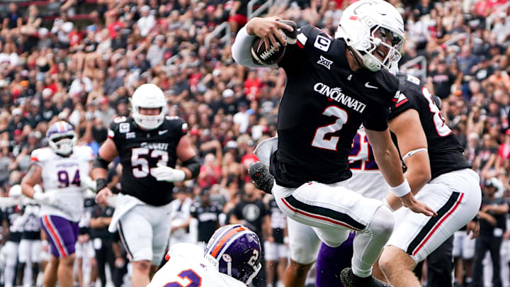Cincinnati Bearcats quarterback Brendan Sorsby (2) jumps over Northwestern State Demons cornerback Antonio Hall (2) in the second quarter of a NCAA men’s college football game between the Cincinnati Bearcats and Northwestern State Demons, Saturday, Sept. 13, 2025, at Nippert Stadium in Cincinnati. Bearcats are up 56-0 by halftime. Cincinnati Bearcats quarterback Brendan Sorsby (2) jumps over Northwestern State Demons cornerback Antonio Hall (2) in the second quarter of a NCAA men’s college football game between the Cincinnati Bearcats and Northwestern State Demons, Saturday, Sept. 13, 2025, at Nippert Stadium in Cincinnati. Bearcats are up 56-0 by halftime.